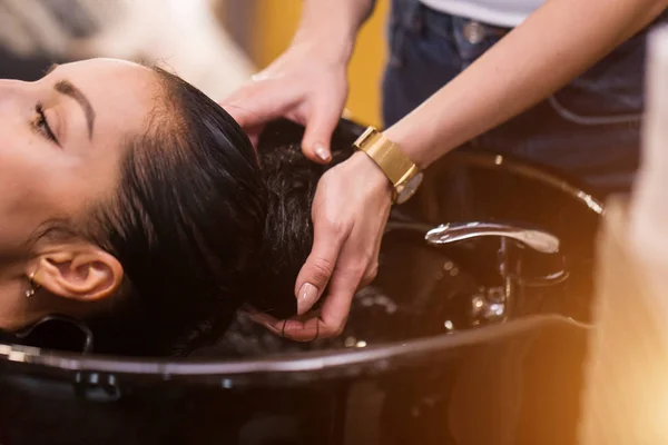 O perto de mãos o cabeleireiro lava o cabelo do cliente. Spa, cuidado, beleza e conceito de pessoas — Fotografia de Stock