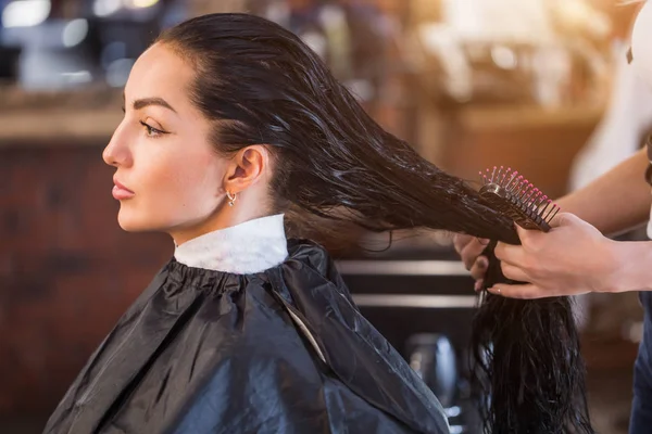 Cabeleireiro feminino penteia o cabelo do cliente — Fotografia de Stock