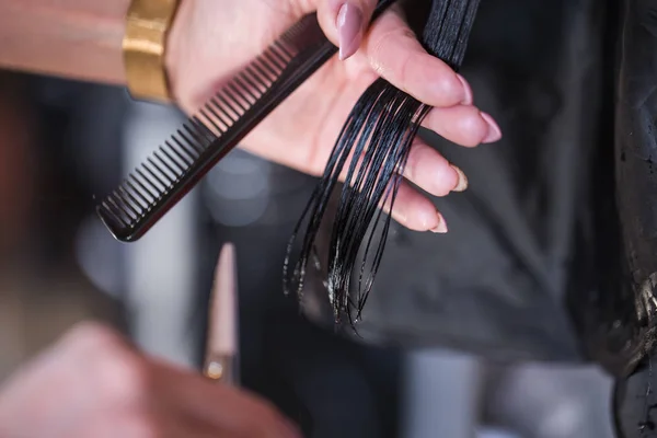 Recortado tiro de una peluquera femenina corte de pelo clientes con tijeras en el salón de belleza —  Fotos de Stock