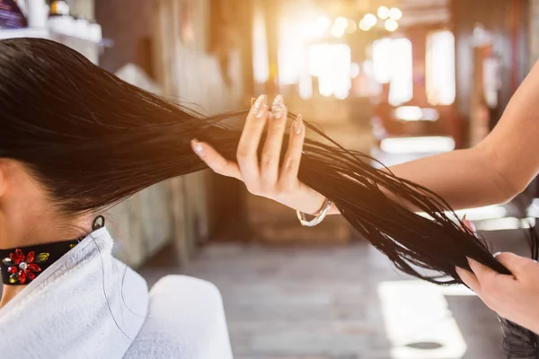Cuidados com o cabelo no moderno salão de spa. mulher cabeleireiro aplica uma máscara ou óleo no cabelo — Fotografia de Stock