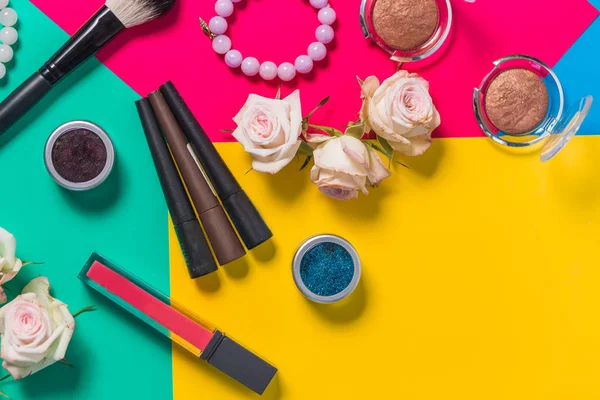 Masih hidup fotografi, kosmetik untuk multi-berwarna latar belakang cerah, merah muda, kuning, hijau, lipstik — Stok Foto