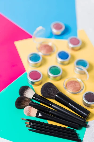 Profesyonel makyaj fırça ve çok renkli bir arka plan üzerinde kozmetik — Stok fotoğraf