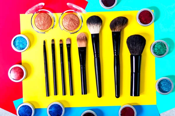 Makyaj fırçaları ve renkli arka plan üzerinde göz farı — Stok fotoğraf