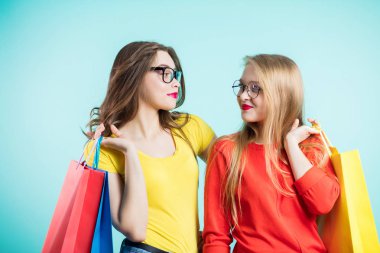 İki kız birbirine bakarak bir gülümseme ile. Gençlik, shopping, moda.