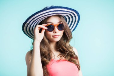 Bikini, şapka ve güneş gözlüğü sahilde duran genç güzel kadın. yaz tatil ve tatil kavramı.
