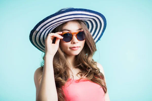 穿着比基尼、帽子和太阳镜的年轻漂亮女子站在沙滩上。暑假和假期概念. — 图库照片