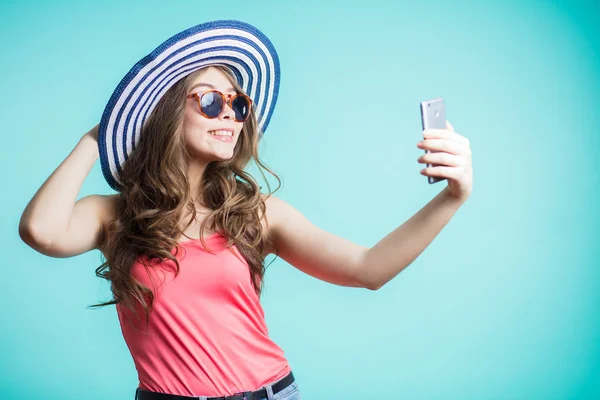 Mujer joven feliz en sombrero y gafas de sol tomando selfie —  Fotos de Stock