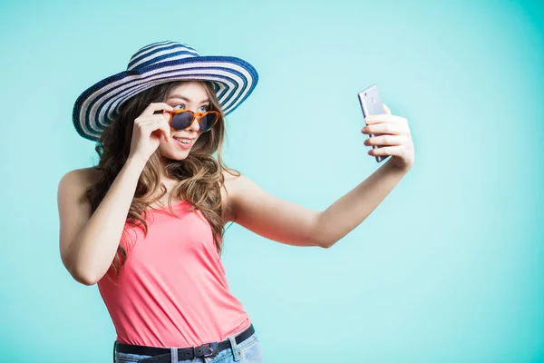 Verrast jonge vrouw neemt een selfie, grappige gezicht, grimas. Het meisje droeg een hoed — Stockfoto