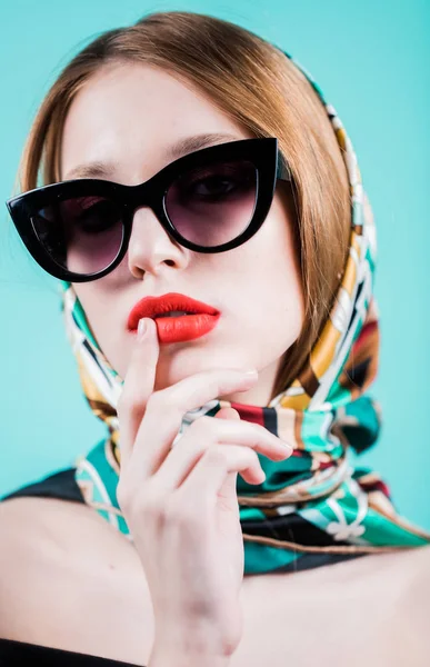 Primer plano de mujer joven con estilo en gafas de sol sonriendo sobre fondo azul. Hermosa modelo femenina con espacio de copia. —  Fotos de Stock