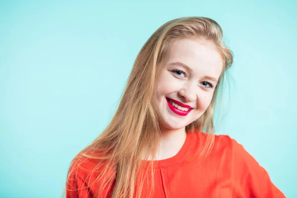 Jovem bonito sorridente menina no fundo azul . — Fotografia de Stock