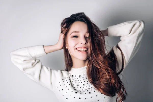 Una donna sorridente e felice. Giovane ragazza divertente su uno sfondo bianco. Emozioni positive sincere — Foto Stock
