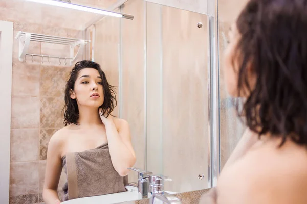 Mulher morena bonita após o banho olhando no espelho — Fotografia de Stock