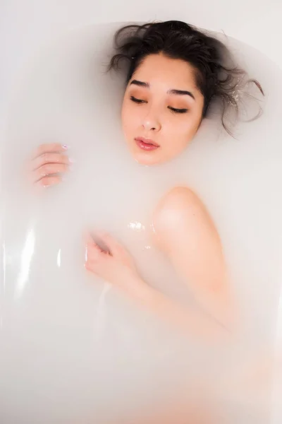 Jolie fille prend un bain avec du lait. Traitements spa — Photo