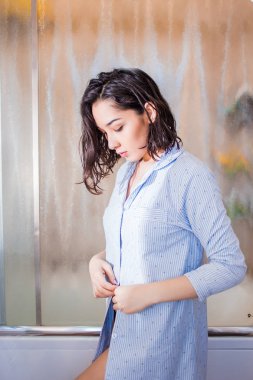 Güzel esmer kadın gömlek düğmeleri takılır
