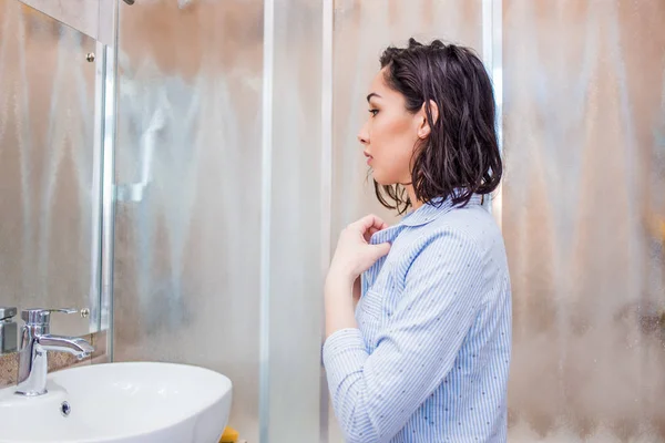 Une femme se regarde dans le miroir après un showe — Photo