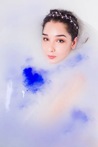 Красива жінка в біло-блакитній воді в лазні — стокове фото