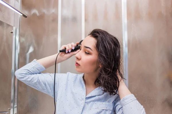 Hermosa mujer está usando un secador de pelo — Foto de Stock