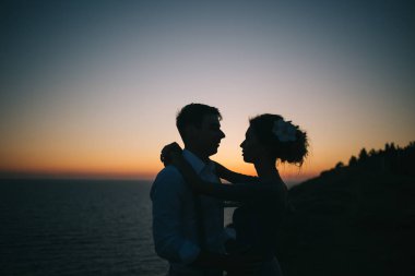 Deniz, bir erkek ve bir kadın sarılma ve her diğer, yakın çekim seyir, güzel gün batımı