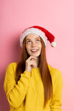 Güzel beyaz kadın model Noel Baba şapkası giyiyor.