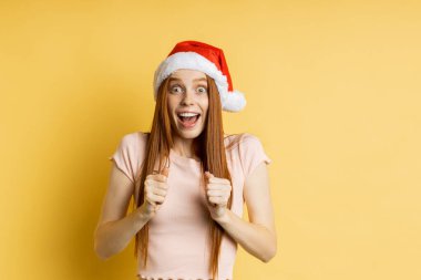 Güzel beyaz kadın model Noel Baba şapkası giyiyor.