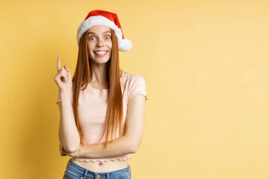 Güzel beyaz kadın model Noel Baba şapkası giyiyor.