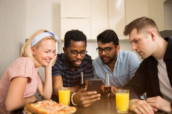 Молодые друзья едят пиццу дома — стоковое фото