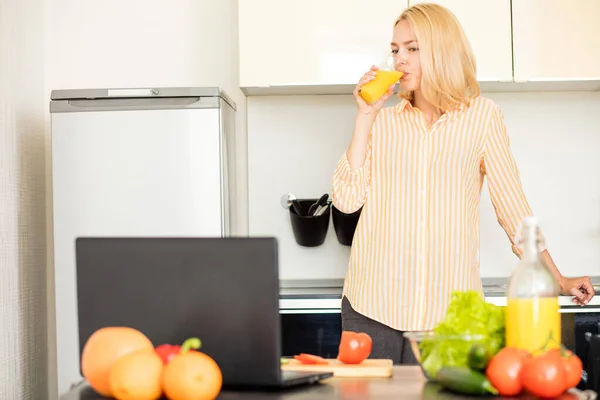 Mulher usando laptop na cozinha — Fotografia de Stock