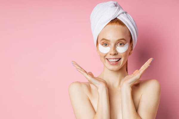 Молодая женщина с пятнами под глазами изолированы на розовом фоне
