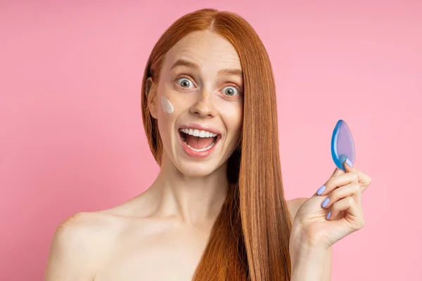 Potret wanita muda yang mengenakan krim wajah dan wajah bersih dengan spons — Stok Foto