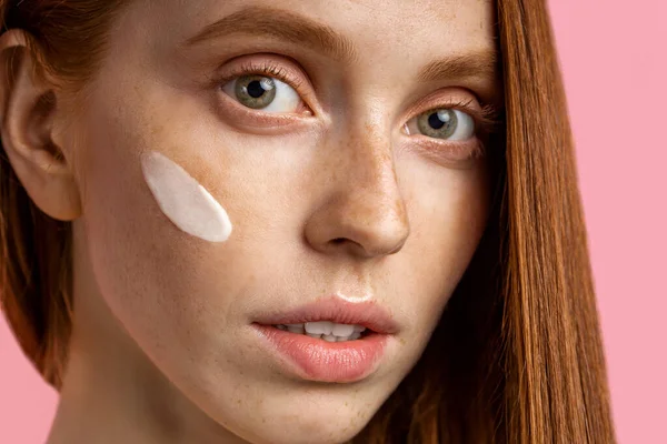 Hermosa joven pelirroja con crema en la cara — Foto de Stock