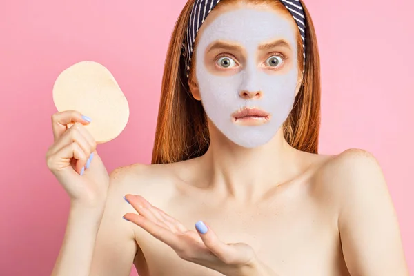 Beautiful woman with facial mask on pink background — Stock Photo, Image