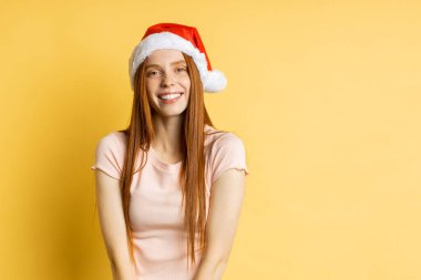 Güzel beyaz kadın model Noel Baba şapkası giyiyor.