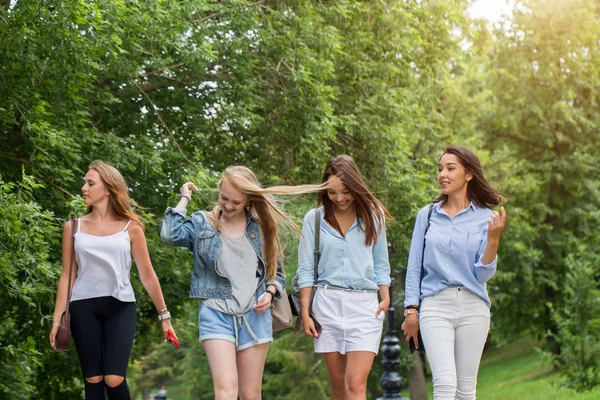 Primer plano del grupo de cuatro novias que van a casa después de caminar juntos en el parque. alumnas caminando después del estudio — Foto de Stock