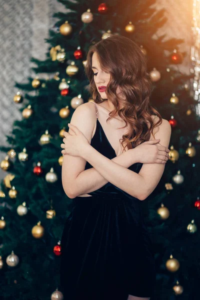 Férias, celebração e conceito de pessoas - jovem mulher em vestido elegante sobre fundo interior de Natal. Menina em vestido preto — Fotografia de Stock