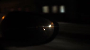 Gece sokağı. Dikiz aynasında gece araba sürerken