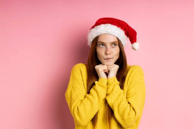 Güzel beyaz kadın model Noel Baba şapkası giyiyor.