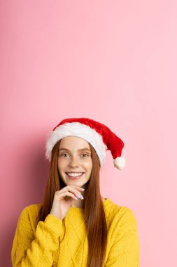 Güzel beyaz kadın model Noel Baba şapkası giyiyor.