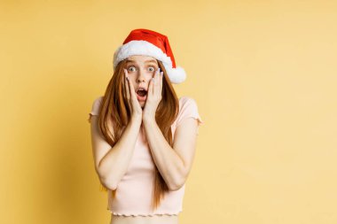 Güzel beyaz kadın model Noel Baba şapkası giyiyor.