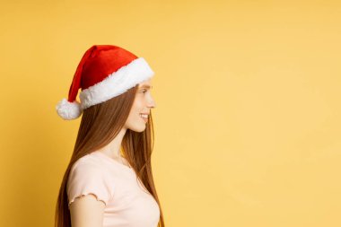 Güzel beyaz kadın model Noel Baba şapkası giyiyor.