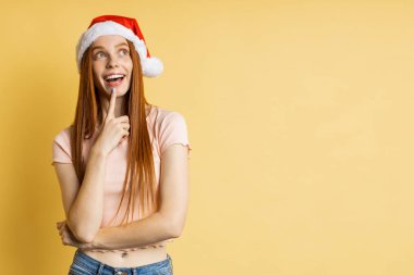 Güzel beyaz kadın model Noel Baba şapkası giyiyor.