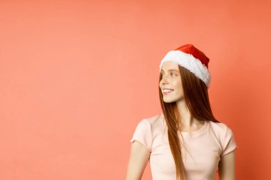 Güzel beyaz kadın model Noel Baba şapkası giyiyor.