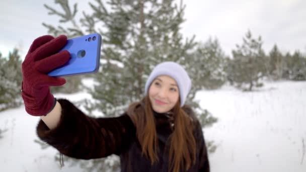Молода жінка посміхається зі смартфоном — стокове відео