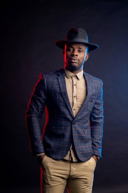 Siyah şapkalı havalı Afro-Amerikan adam koyu arka planda