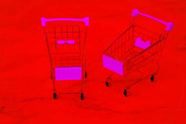 Paslanmaz çelik alışveriş arabaları. Metal süpermarket alışveriş arabası. Kırmızı arka planda iki boş alışveriş arabası. Alışveriş konsepti.