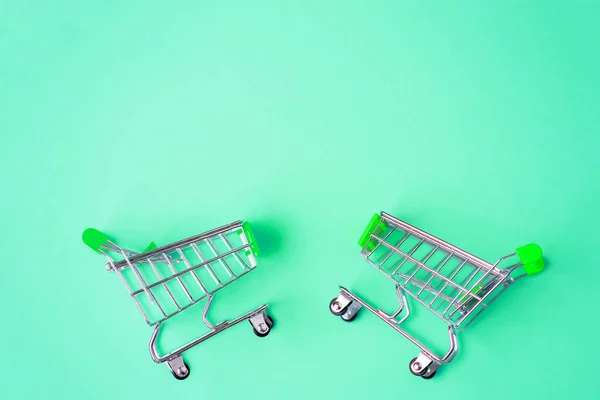 Два Небольших Миниатюрных Металлических Тележки Супермаркета Изолированы Ярком Мятном Фоне — стоковое фото