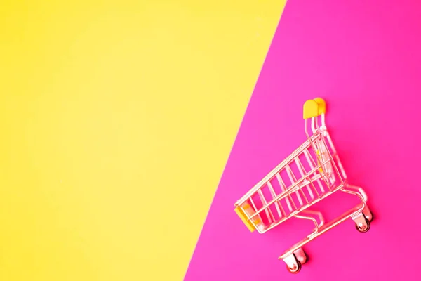 空的不锈钢购物车隔离在粉红色和黄色背景与复制空间为您的文字或设计 顶视图 平铺购物车 超级市场 销售概念 — 图库照片
