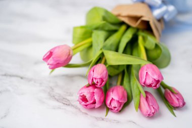 Beyaz mermer bir masanın üzerindeki pembe bir buket çiçeğin yakın çekimi. Bahar, yaz, çiçekler, konsept