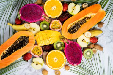 Beyaz arka planda çeşitli olgun sulu taze tropikal yaz mevsimlik meyveler. Tatil, sağlıklı yiyecekler, diyet, yaz konsepti. Masada dilimlenmiş meyve. Üst görünüm.