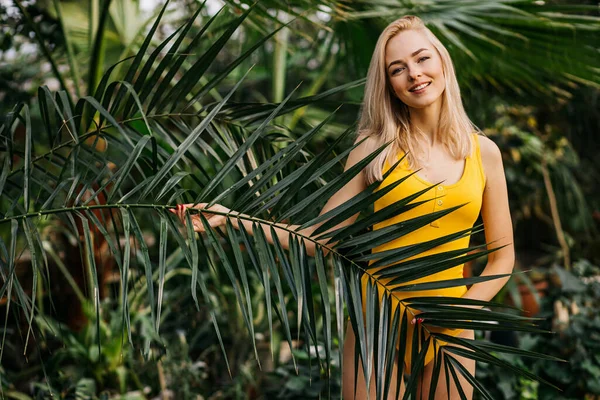 Donna in costume da bagno su sfondo piante tropicali — Foto Stock