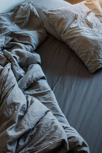 Geceleri uyuduktan sonra mavi yatak çarşafları ve yastıklar.